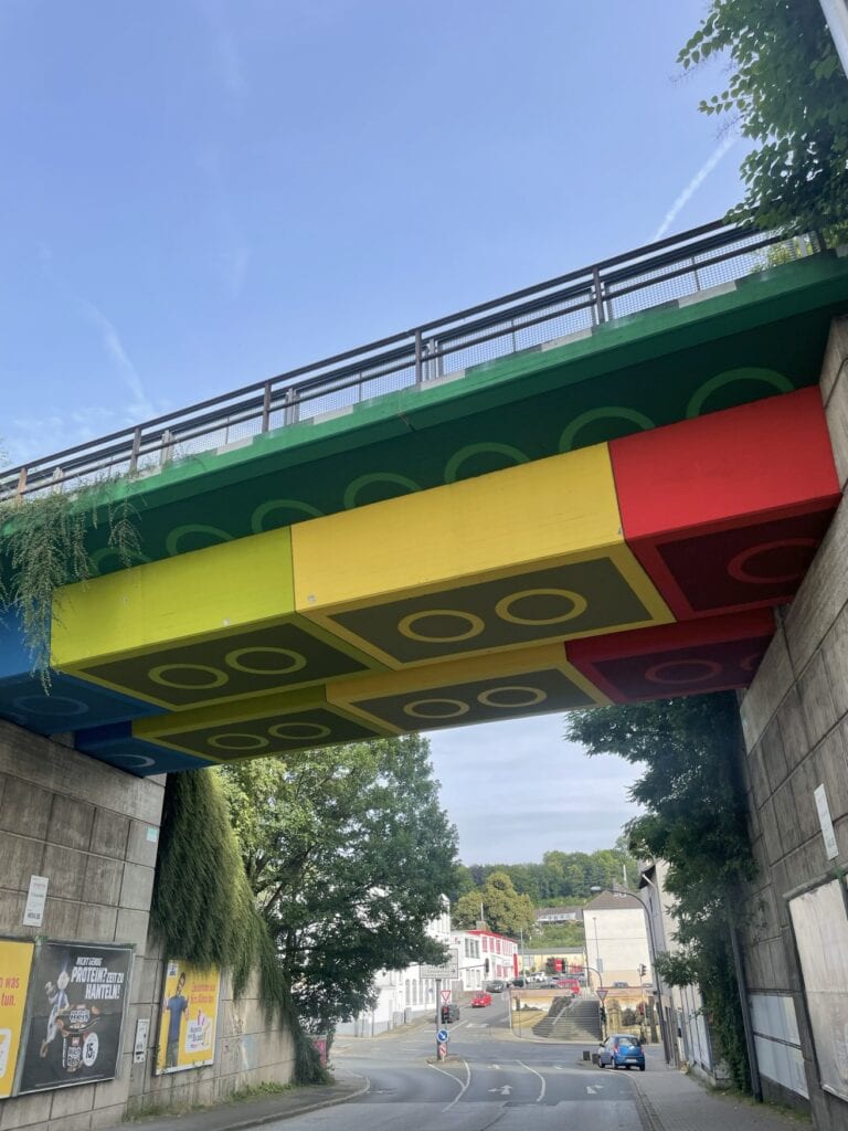 Eine Brücke in Wuppertal, die auf der Unterseite so bemalt ist, dass sie wie aus bunten Legosteinen zusammengesetzt aussieht