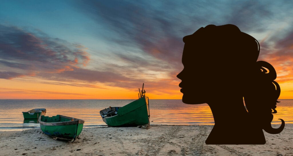 Silhouette einer Frau vor Fischerbooten an der Ostseeküste
