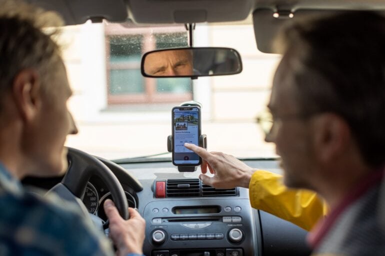 Zwei Personen bedienen die App "signseeing" in einem Auto