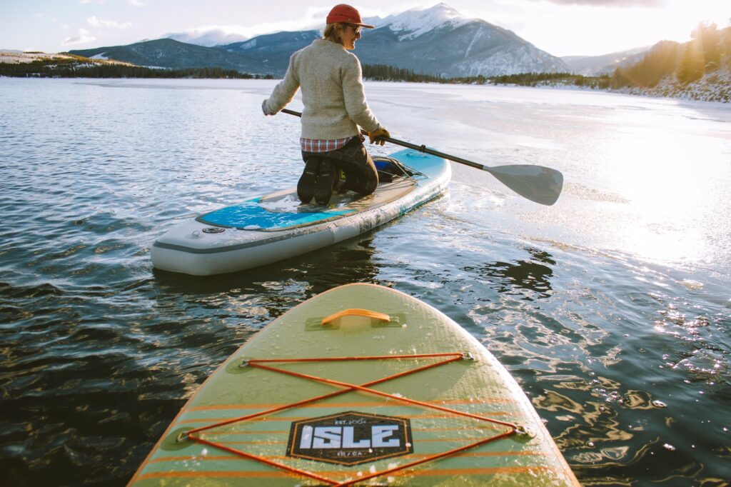 A person kajaks on a mountain lake