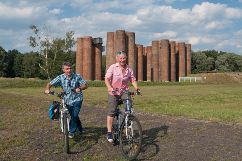 Two persons ride bicycles in front of the bio towers in Lauchhammer in Brandenburg