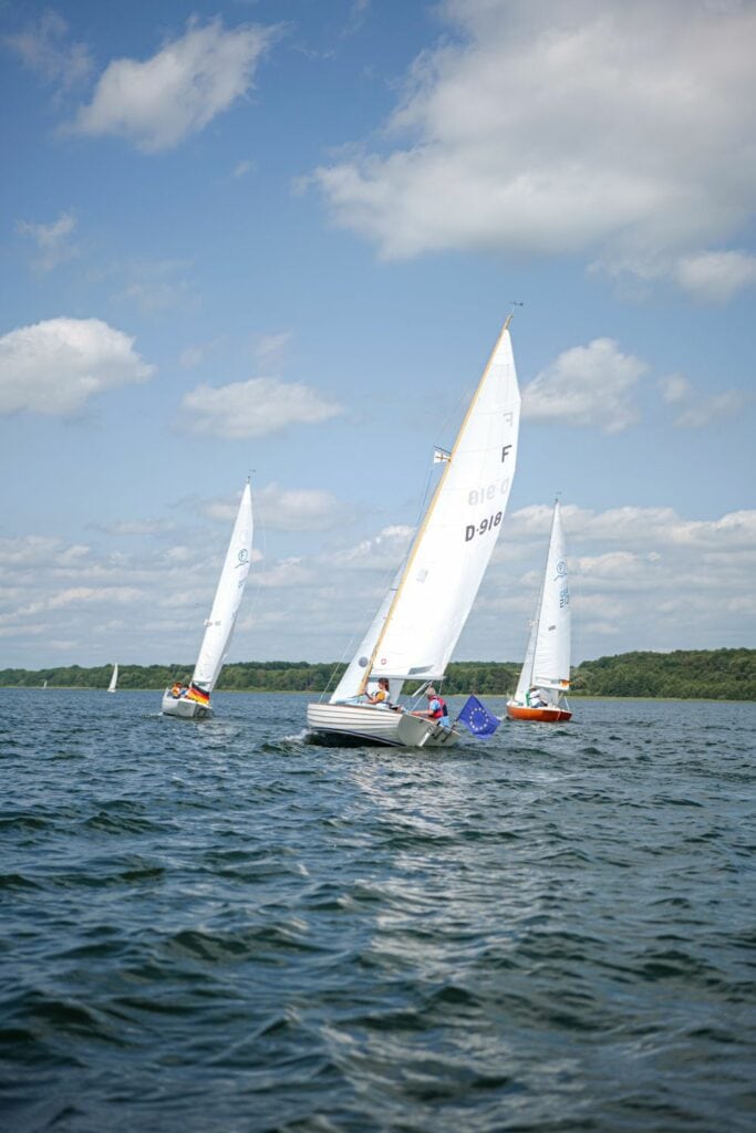 Drei Segelboote fahren auf einem See im Herzogtum Lauenburg