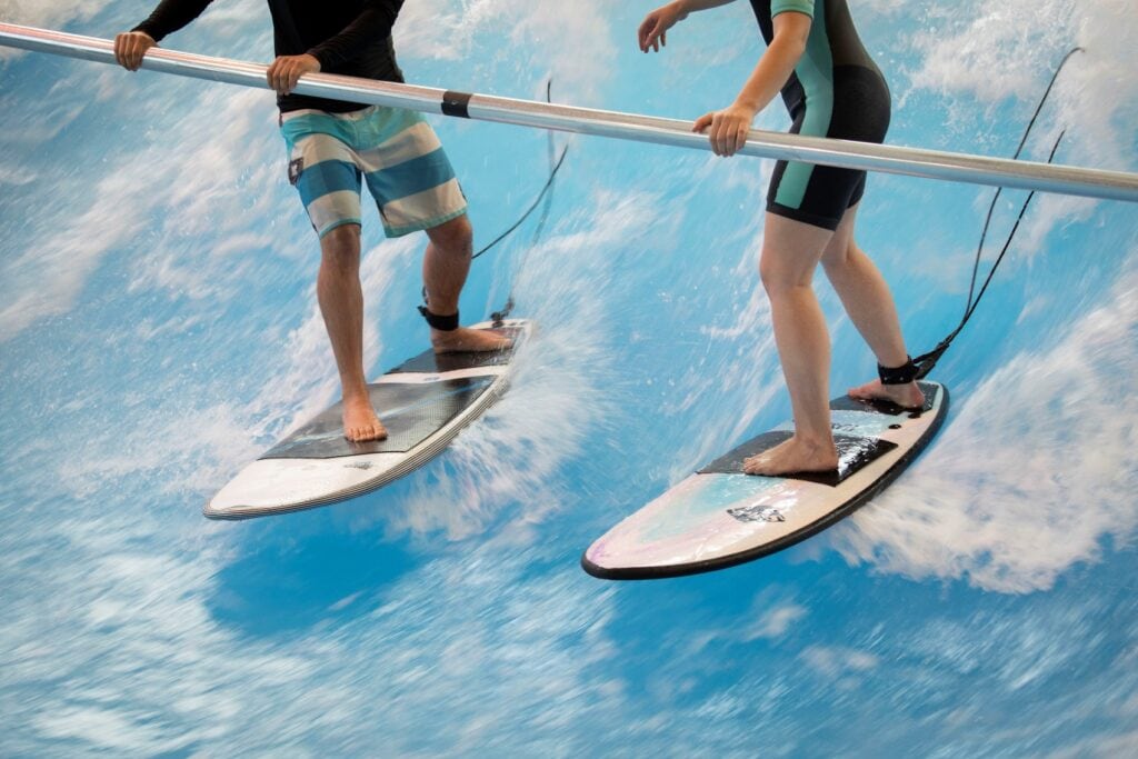 Zwei Personen surfen auf einer künstlichen Welle