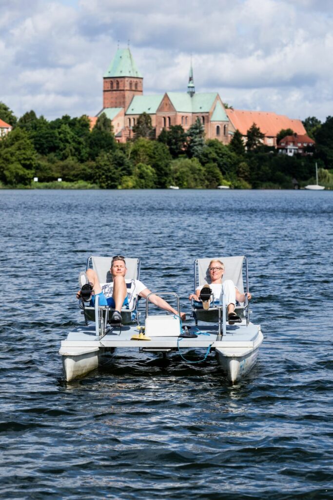 Two people ride a pedal boat on a lake
