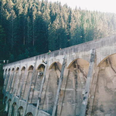 A man climbing down the Linach Dam with a rope in the black forest