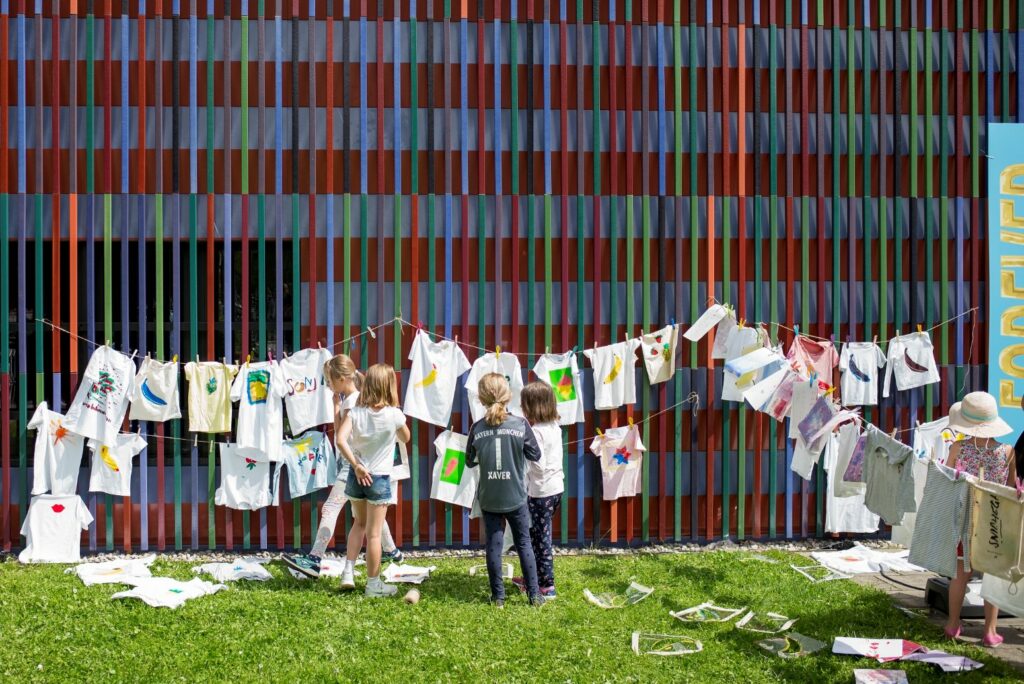 Children hang printed T-shirts to dry