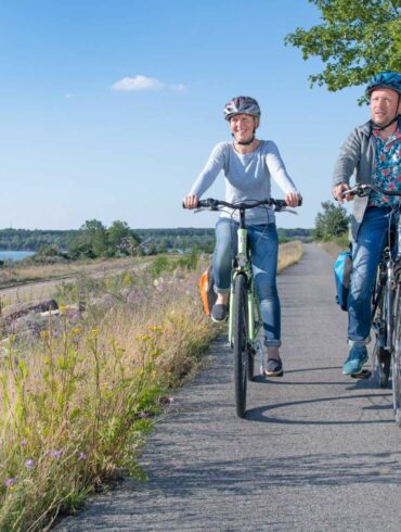 Two people biking along a lake in the Lausitz region