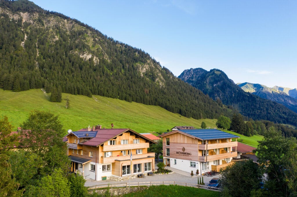 Blick auf das Hotel Kühberg im Allgäu, im Hintergrund die Alpen