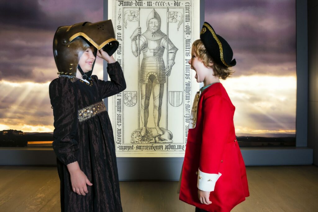 Two children try on historical costumes