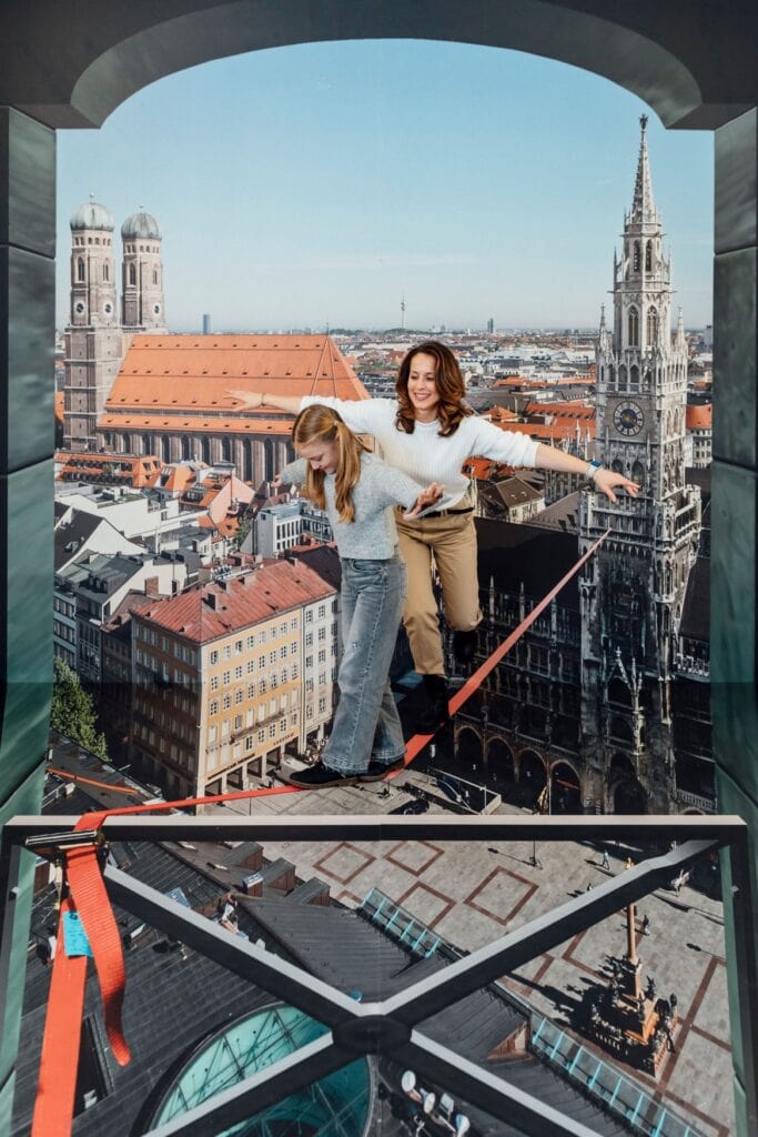 Im Museum "Magic Bavaria" in München balancieren eine Frau und ein Kind scheinbar mittels einer Illusion über dem Marienplatz