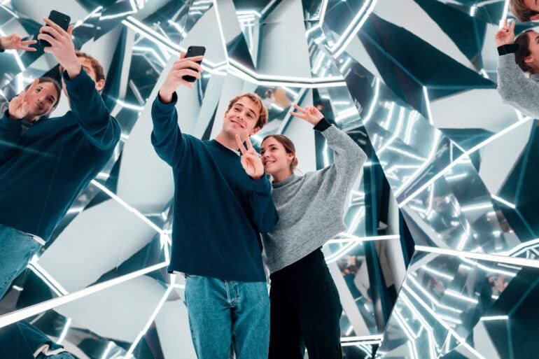 Ein Mann und eine Frau machen ein Selfie in einem modernen Spiegelkabinett im Museum "Magic Bavaria" in München