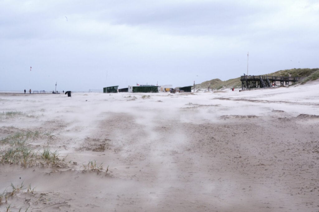 Am Strand von Amrum wird der Sand durch starken Wind aufgeweht
