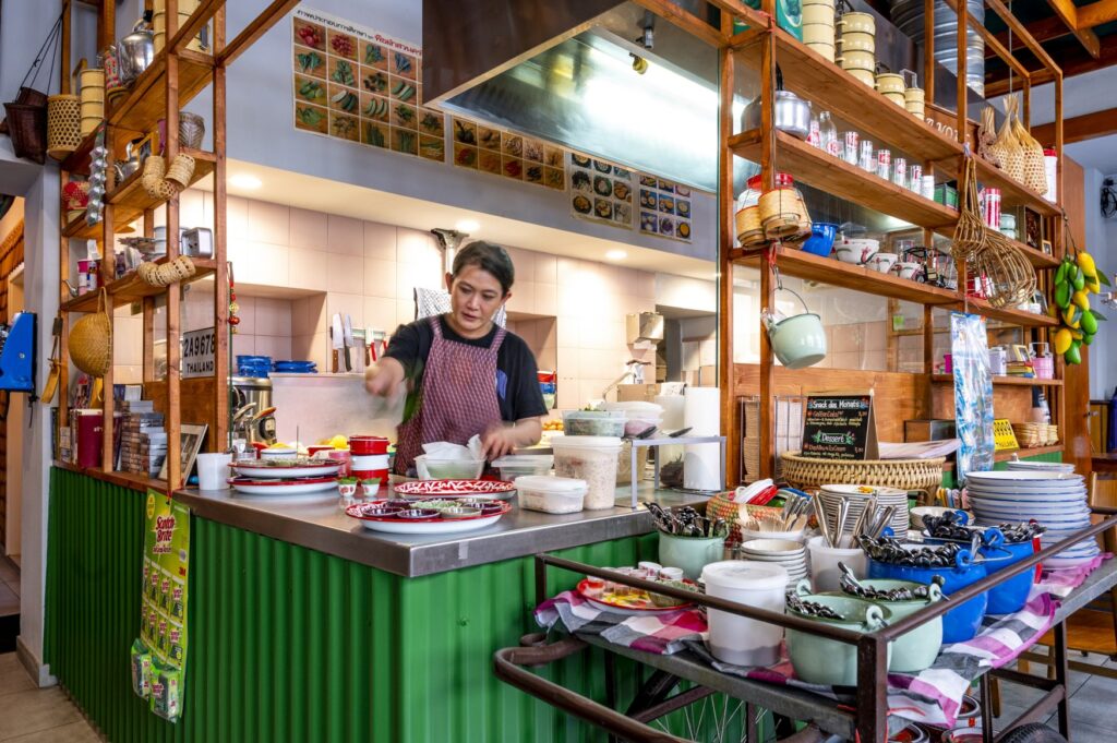 Owner Visnee Lips prepares a dish behind the counter in her restaurant Soi 39 in Mannheim.