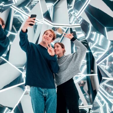 A man and a woman take a selfie in a modern hall of mirrors in the "Magic Bavaria" museum in Munich
