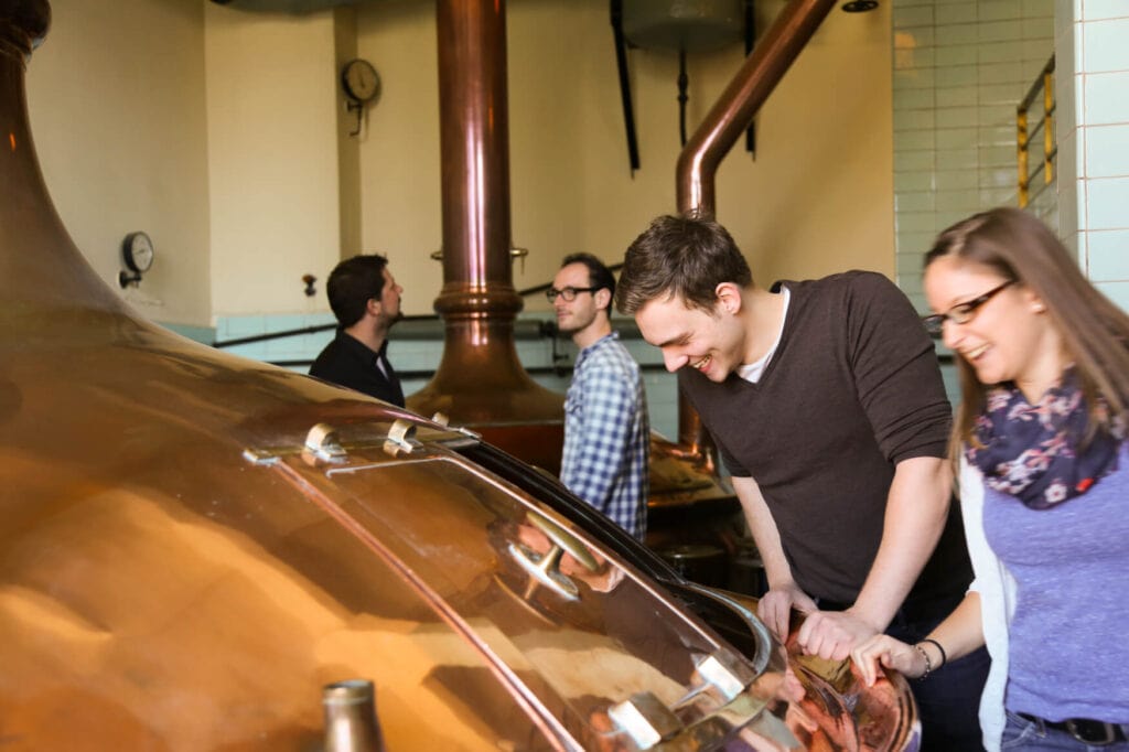 Einige BesucherInnen schauen in der Bier-Erlebniswelt Maisel in Bayreuth in einen Tank