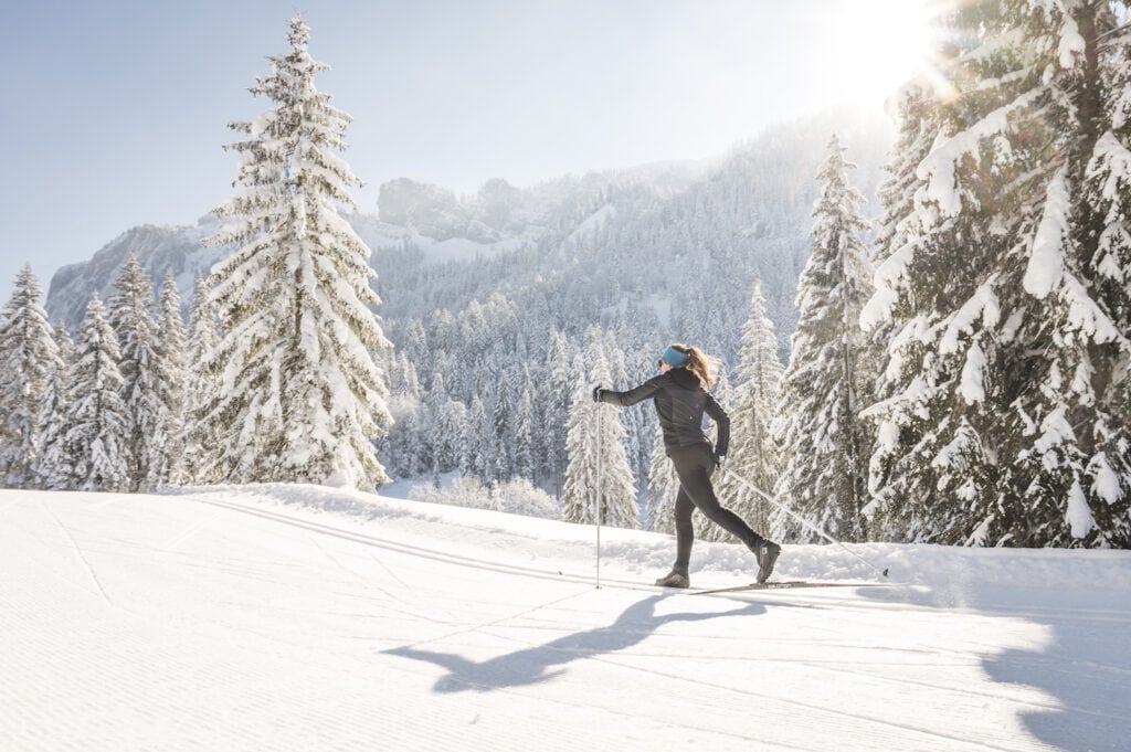 Ein Langläufer in einem verschneiten Wald in Bayern