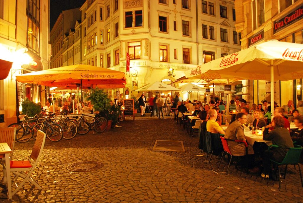 A street on Leipzig's Drallewatsch in the evening, the outdoor café is well filled
