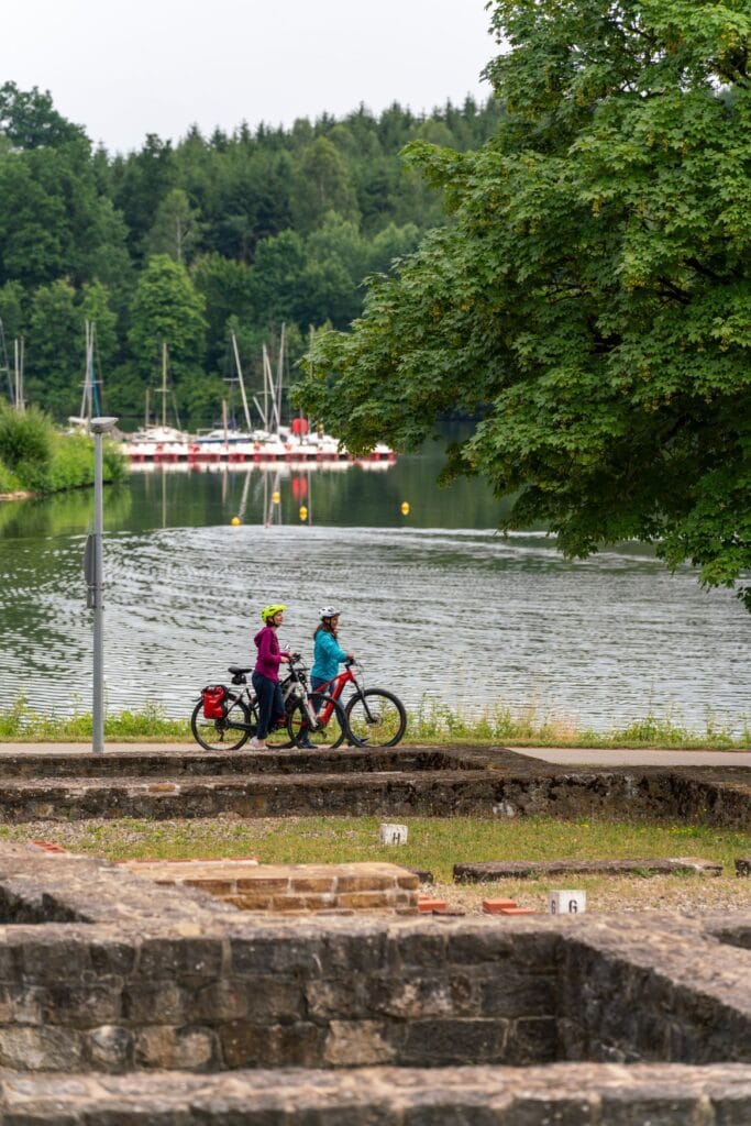 Zwei Radlerinnen stehen mit ihren Fahrrädern vor dem Bucher Stausee in Baden-Württemberg