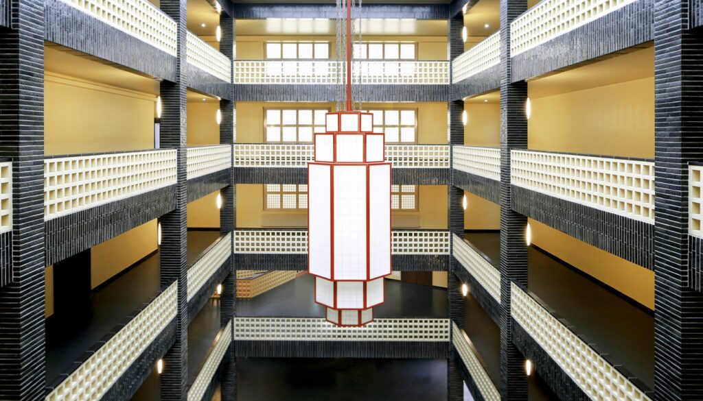 Staircase in the Haus des Rundfunks photographed from one of the upper floors, with a large chandelier in the center of the picture