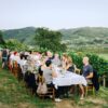 Eine Picknick-Gesellschaft sitzt an einem gedeckten Tisch auf einem Hügel, im Hintergrund idyllisches Schwarzwald-Panorama.
