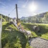 Eine Frau rutscht mit ihrem Kind auf einem Spielplatz im Chiemsee-Alpenland