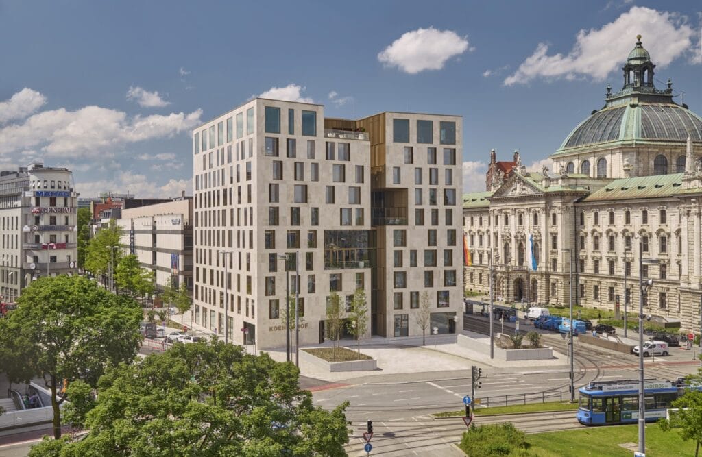 Außenansicht des Hotels Koenigshof in München, ein weißes, würfelförmiges Gebäude mit zahlreichen Fenster-Einlassungen.