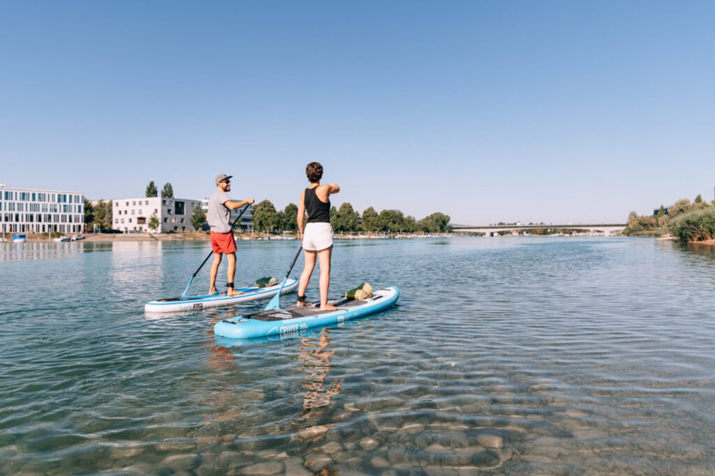 Zwei Personen paddeln auf SUP über den sonnigen Bodensee