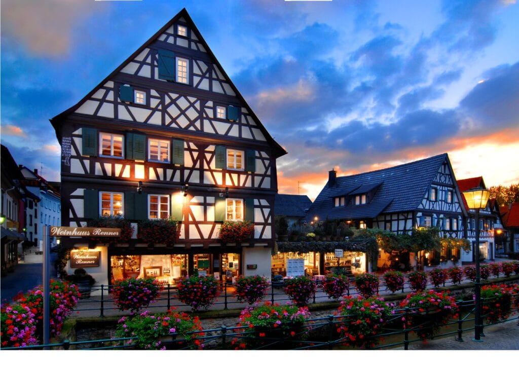 Das Weingut Julius Renner in Oberkirch. Die helle Fachwerk-Fassade zeichnet sich vor einem dunkelblauen Abendhimmel ab