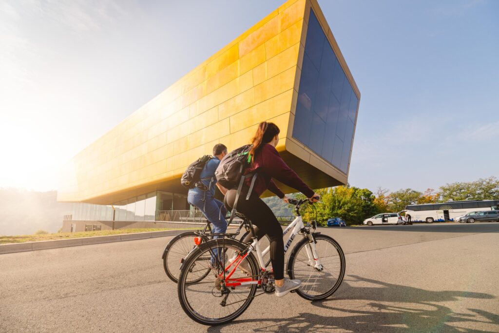 Two cyclists on a cycle path in front of the Nebra Ark in the Saale-Unstrut region