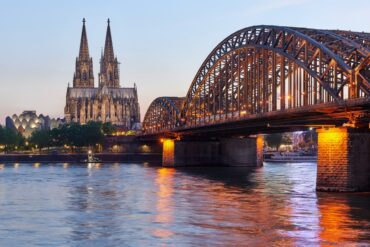 Die Hohenzollernbrücke in Köln im Abendlicht, im Hintergrund der Dom