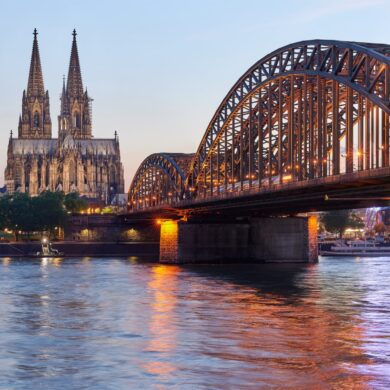 Die Hohenzollernbrücke in Köln im Abendlicht, im Hintergrund der Dom