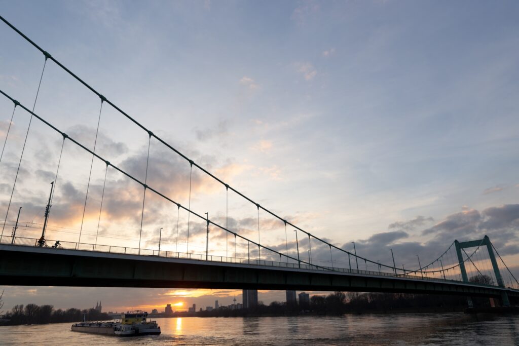 Die Mülheimer Brücke in Köln im Sonnenuntergang, mit Perspektive Richtung Süden