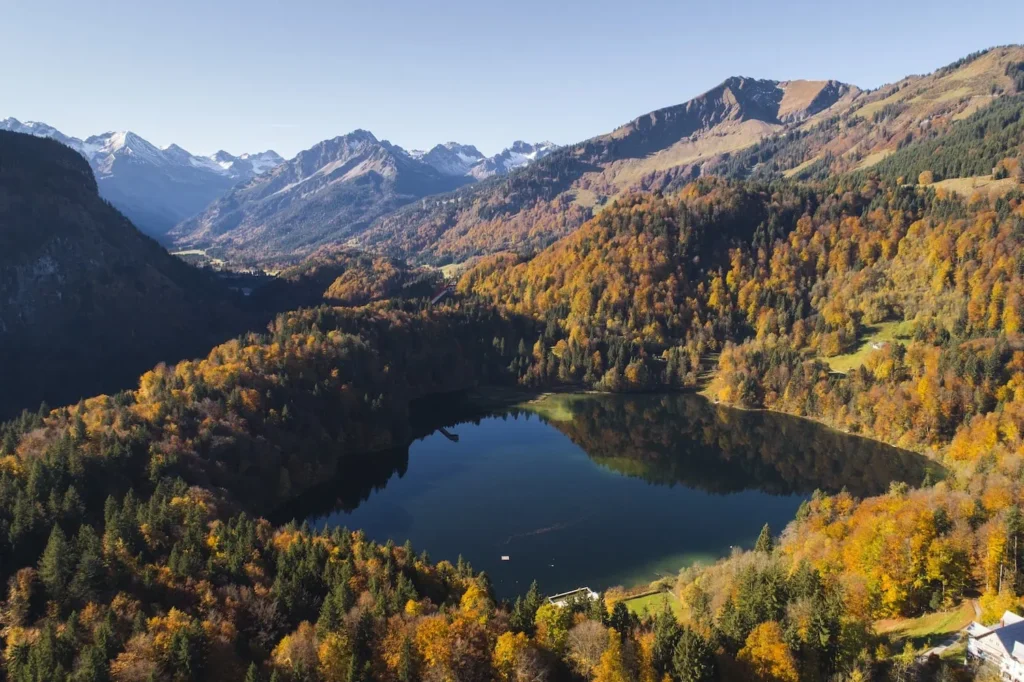 A lake in the Oberstdorf Alps, surrounded by colorful autumn forests.