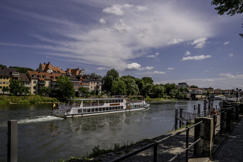 Ein Schiff fährt über die Donau in Regensburg