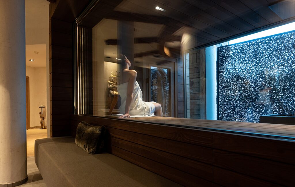 A woman in a towel is sitting in the sauna at the Meiser Vital Hotel in Fichtenau.