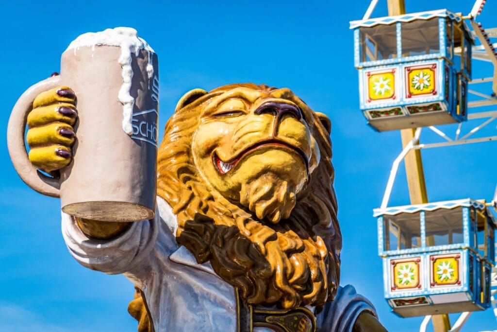 Eine Löwenfigur hebt eine Maß Bier auf dem Oktoberfest