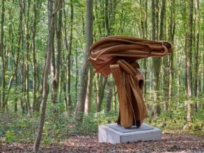 Eine Bronzeskulptur umringt von Bäumen im Skulpturenpark Waldfrieden in Wuppertal