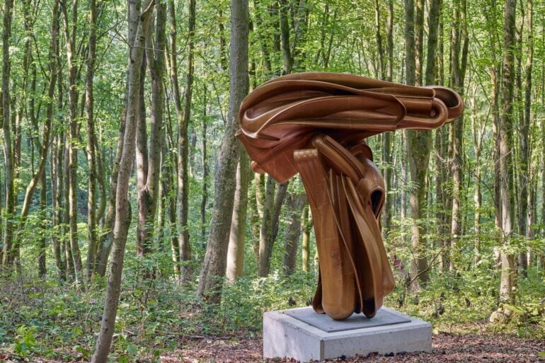 Eine Bronzeskulptur umringt von Bäumen im Skulpturenpark Waldfrieden in Wuppertal