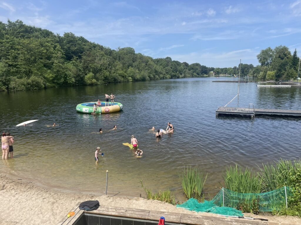 Menschen genießen die Sonne in einem der Seen der Sechs-Seen-Platte