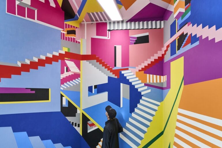 A colorful mural at the Wow Museum in Munich that resembles a drawing by M. C. Escher