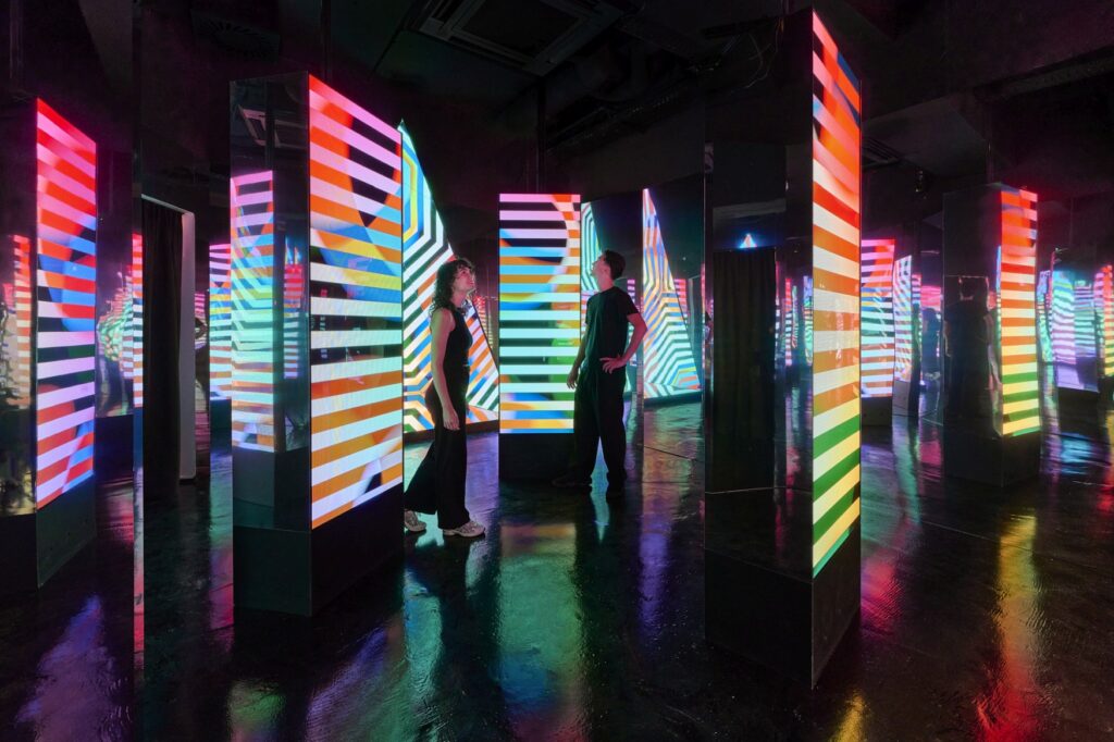 The colorful screens at the Wow Museum in Munich are arranged like a hall of mirrors.