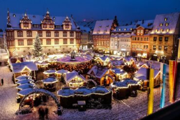 Der verschneite Coburger Weihnachtsmarkt, von Schnee bedeckt in nächtlichem Lichterglanz