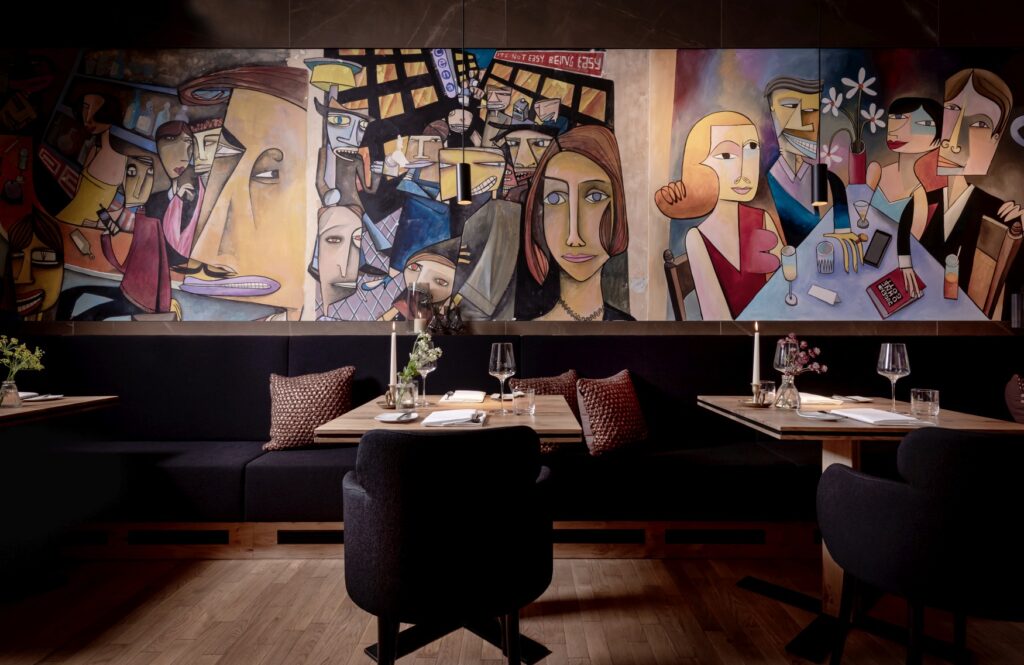 Interior of the Horváth restaurant in Berlin, with large paintings above the tables