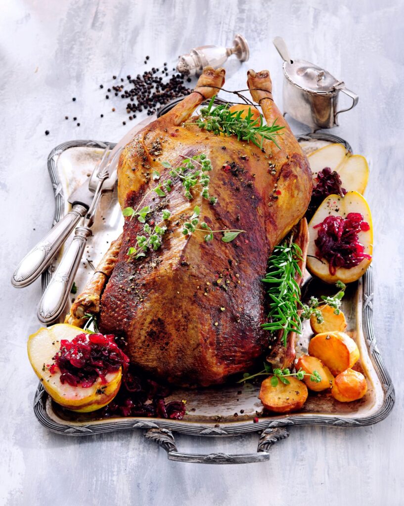 Roast goose with side dishes on a festively decorated table