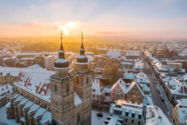 Die Sonne geht im Advent über dem schneebedeckten Bayreuth auf