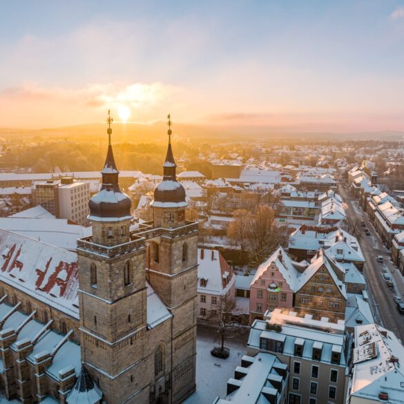 Die Sonne geht im Advent über dem schneebedeckten Bayreuth auf