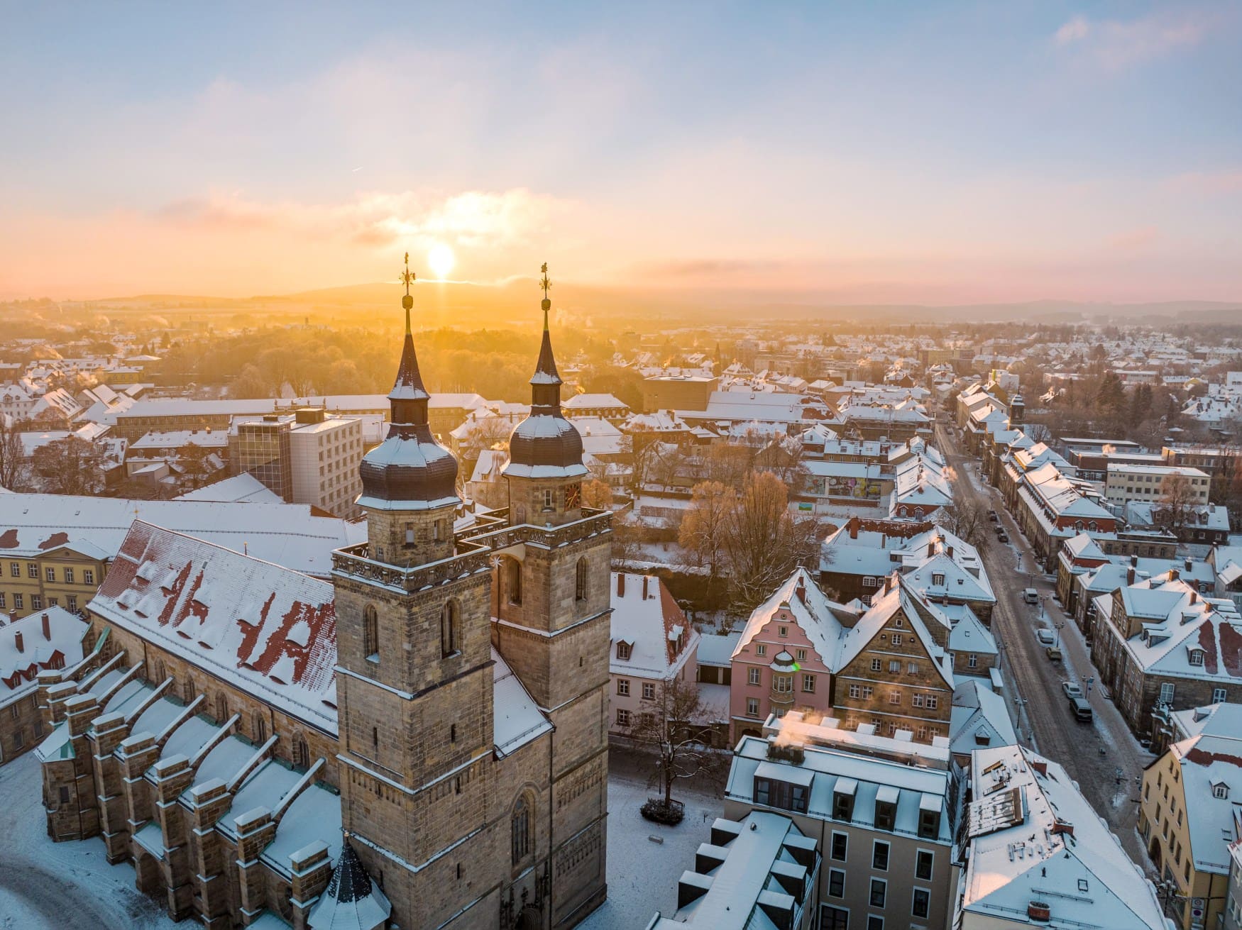 Die Sonne geht im Advent über dem schneebedeckten Bayreuth auf