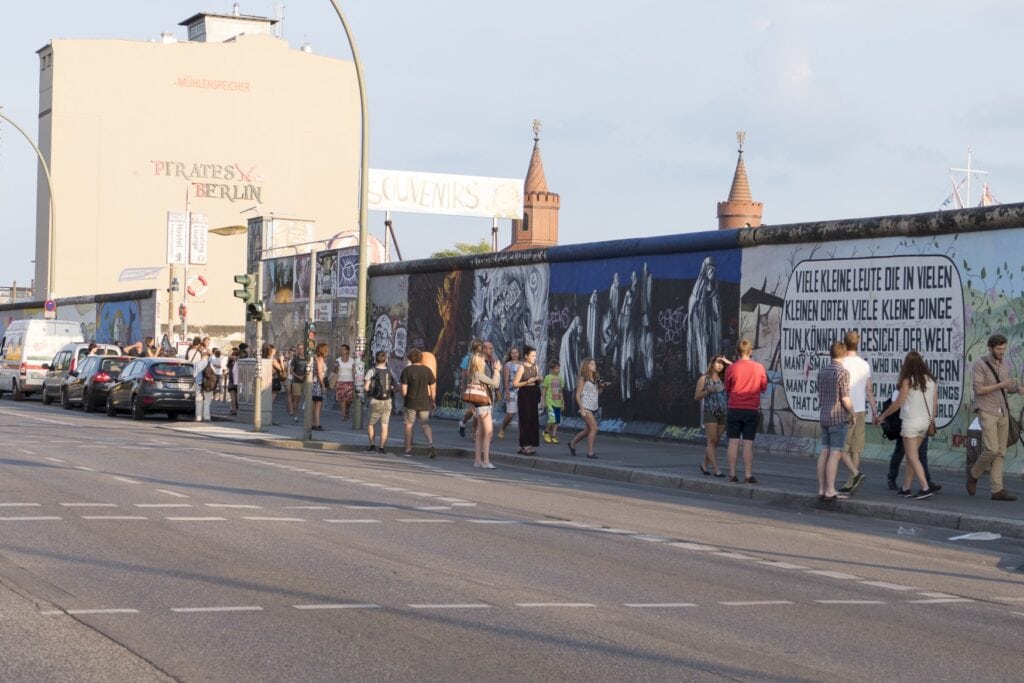 Viele Menschen gehen an einem Abschnitt der East Side Gallery in Berlin entlang