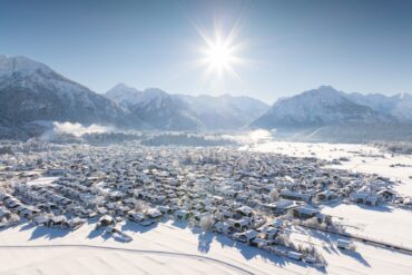 Die Sonne scheint auf das verschneite Oberstdorf im Winter in den Alpen