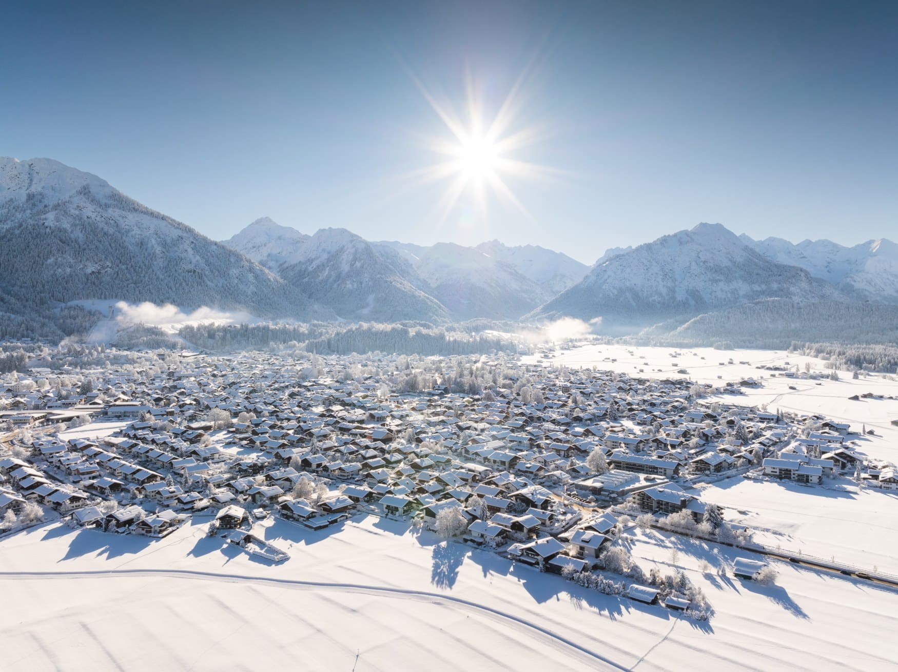 Die Sonne scheint auf das verschneite Oberstdorf im Winter in den Alpen